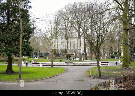 Stadtparkweg mit Bäumen, Bänken und Brunnen Calais France Stockfoto