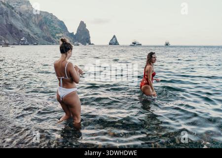 Frauen, Strand, Meer. Zwei Frauen, die sich im ruhigen Wasser an einer wunderschönen felsigen Küste entspannen. Stockfoto
