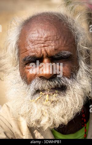 Nahaufnahme eines älteren Mannes, der sich in Varanasi, Indien, die Zähne putzt, zeigt detaillierte Gesichtszüge und Bart. Stockfoto