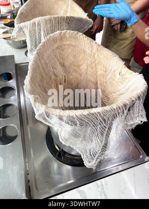 Traditionelle thailändische Küche mit einem Musselin-Tuch über einem Topf für die Zubereitung von Mango-Kleberreis-Dessert in einer modernen Küche Stockfoto