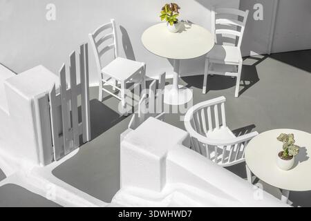 Griechenland. Santorini. Thira Insel. Weißer Tisch und Stühle auf einer Sonnenterasse Stockfoto