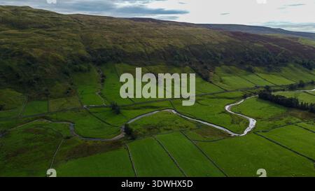 Blick aus der Vogelperspektive auf den Fluss Skirfare, der sich durch ein Raster von ummauerten Weiden in der Landschaft von Littondale schlängelt Stockfoto
