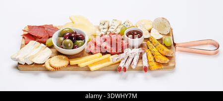 Antipasti auf einem Holzbrett mit verschiedenen Käsesorten, Wurstwaren, Oliven und Trauben Stockfoto