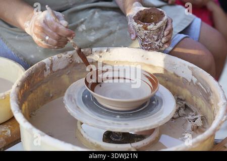 Hände von Mädchen Töpfer, die Schaffung eines irdenen Glas auf dem Kreis, close-up Stockfoto