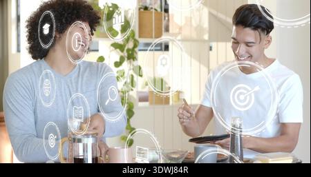 Kaffee machen zwei Männer tragen graues, langärmliges, weißes T-Stück mit Tablet in der Küche mit französischer Presse Stockfoto