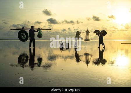 Fischer werfen Netze in flachen Küstengewässern von Hai Hau, Nam Dinh, Vietnam Stockfoto