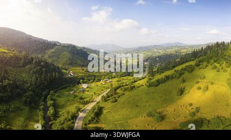 Landschaftlich reizvolle Panoramalandschaft. Luftdrohne Ansicht der malerischen Stadt-Typ Siedlung im Tal zwischen grüner Natur, Nadelwälder, und Karpaten m Stockfoto