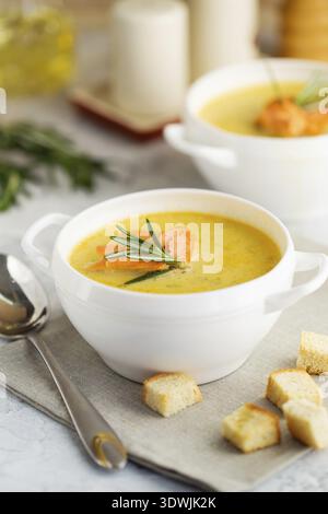 Fischcremesuppe mit Lachs, Käse, Kartoffeln und Kräutern in weißen Suppenschalen Stockfoto