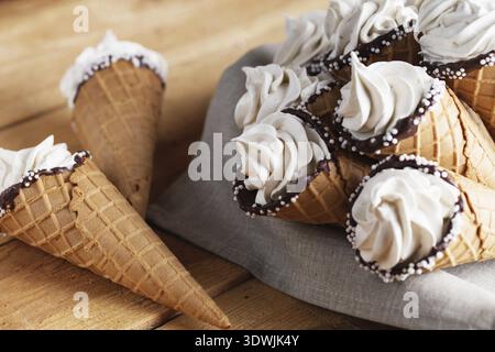 Viele Eiszapfen auf einem Holztisch. Weiches Eis oder gefrorene Cremes in Zapfen. Eiscreme mit Waffel-Marshmallow Stockfoto