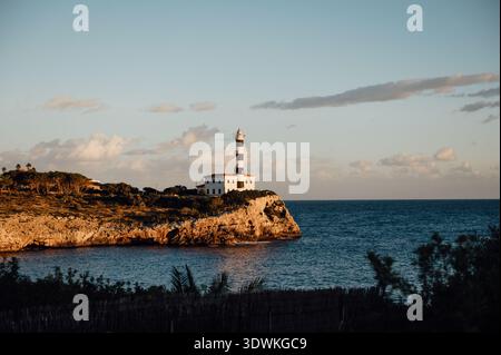 Leuchtturm Far de Portocolom auf einer Klippe über dem Mittelmeer Stockfoto