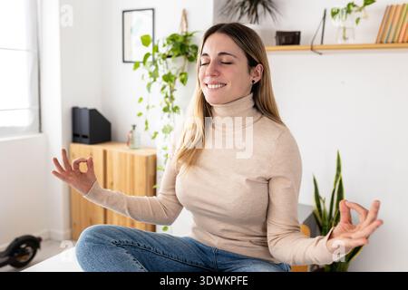 Junge Erwachsene Geschäftsfrau, die Achtsamkeit im Home Office übt Stockfoto