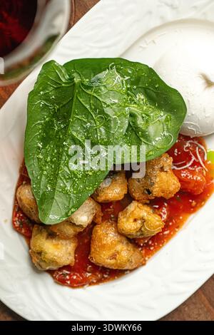 Burrata mit gebratenem Huhn und Rotwein Stockfoto