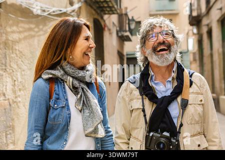 Glückliches Seniorenpaar, das zusammen lacht, während sie in Barcelona Besichtigungen machen Stockfoto