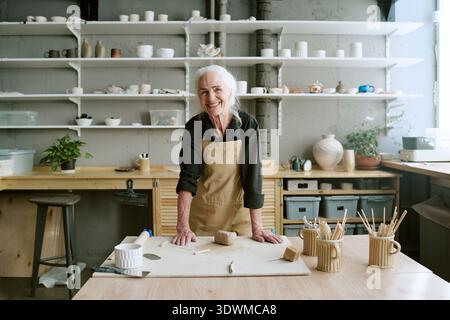 Porträt einer lächelnden Seniorin während der Arbeit im Tonerstudio Stockfoto