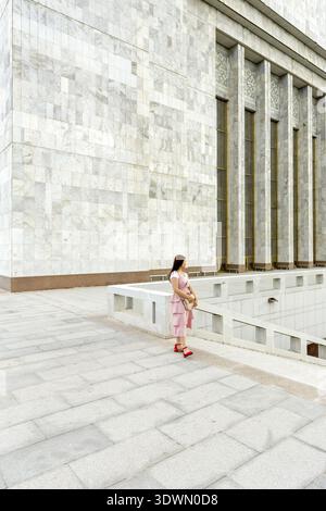Kirgisistan, Provinz Chuy, Bischkek, Kirgisische Frau vor der Fassade des Nationalmuseums für Geschichte, am Ala-Too-Platz Stockfoto