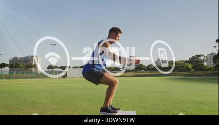 Hockender Mann mit braunem Ball auf der Plybox auf dem Sportplatz, mit blauem Tank, überlagerten Ikonen Stockfoto
