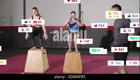 Frau im Squatting Center mit blauem Oberteil, schwarzen Shorts auf Plybox im Fitnessstudio, mit sozialen Ikonen Stockfoto