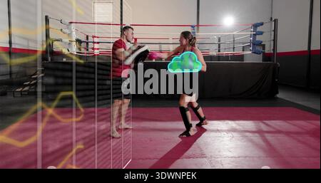 Die gebogenen Polster halten, Trainer in rotem Hemd trainiert den Athleten auf roter Matte, trägt rosafarbene Handschuhe Stockfoto