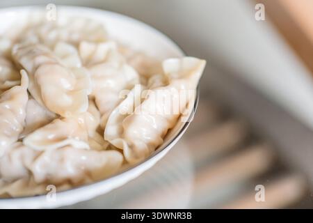 Dämpfen von Knödeln in einer weißen Schüssel, chinesische Küche, Nahaufnahme von Speisen Stockfoto