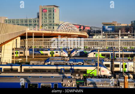 Saint-Denis, Frankreich - 29. Dezember 2025: Zahlreiche Regionalzüge der SNCF parkten am Bahnhof, mit der modernen Brücke Franchissement Urbain Pleyel und dem Hauptsitz der SNCF Group in der Nähe von Paris Stockfoto
