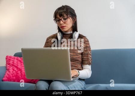 Junge Frau, die Fernunterricht von zu Hause aus genießt Stockfoto