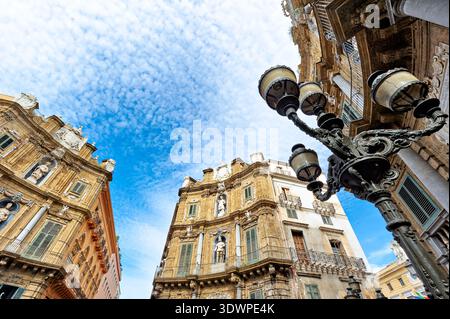 Besucher erkunden den Quattro Canti Platz in Palermo, Sizilien. Die Sonne scheint und Wolken erfüllen den Himmel, während die Menschen die Architektur bewundern. Stockfoto