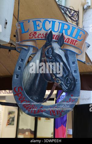 Ein auffälliges hufeisenförmiges Schild mit einem majestätischen schwarz-weißen Pferdekopf empfängt Gäste im Restaurant L'Ecurie in Vieux Nice, Frankreich Stockfoto