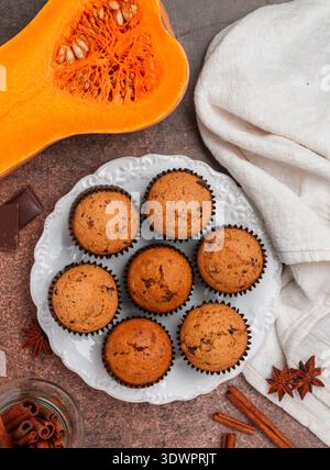 Frisch gebackene hausgemachte Kürbismuffins mit Schokolade und Gewürzen (Zimt, Sternanis, Kardamom). Gesunde hausgemachte Kuchen zum Frühstück. Selektiver lichtwellenleiter Stockfoto