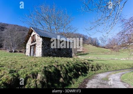 Kleiner, verlassener Bauernhof auf einem Feld in den französischen Pyrenäen an einem sonnigen Tag Stockfoto