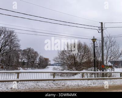 Winter im Lac Boivin in Granby, Quebec, Kanada. Schwimmende Brücke über den Fluss am Ende des Sees. Blick von der Rue de la Gare über den Fluss Yamaska. Stockfoto