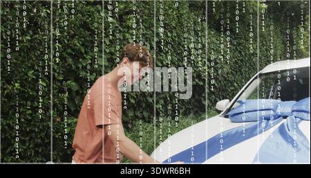 Anlegender Mann im Rost-T-Shirt mit blauer Schleife auf weißem Auto an Hecke mit Doppelüberzug Stockfoto