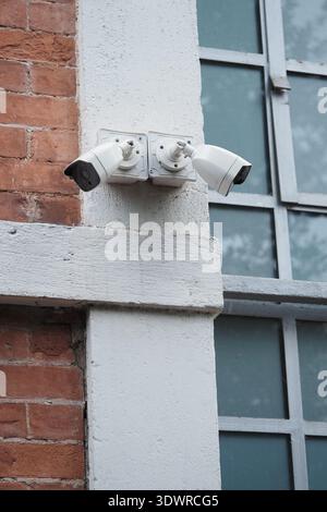 Überwachungskameras auf einem Backsteingebäude in der Stadt Stockfoto