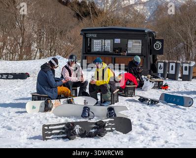 Snowboarder machen eine Pause an einem Kaffeestand im Freien in Hakuba Cortina Japan Stockfoto