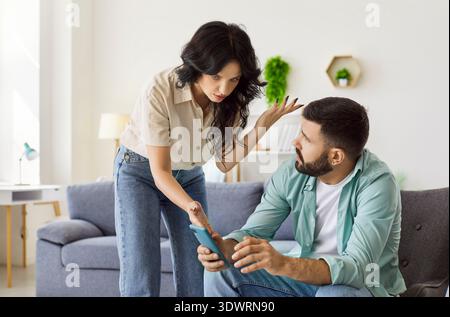 Streit zwischen Paar wegen Smartphone zu Hause, Ehefrau schreit schimpfenden Ehemann Stockfoto