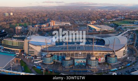 Am Etihad Campus in Manchester bei Sonnenuntergang, mit dem erweiterten Nordstand, dem fast vollständigen Medlock Hotel und dem benachbarten Co-op Live Stockfoto