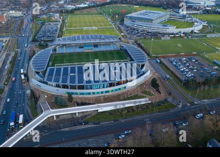Luftbild des Etihad Campus in Manchester bei Sonnenuntergang mit dem Joie Stadium und der Fußgängerbrücke über den Alan Turing Way. Stockfoto