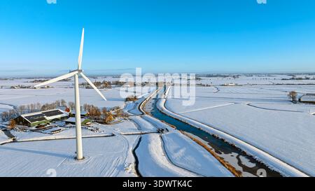 Luftaufnahme einer Windturbine in verschneiten Landschaften im Winter Stockfoto