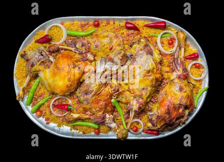 Große Platte mit traditionellem Nahost-Mandi-Reis, garniert mit langsam geröstetem Lammfleisch und Chili-Paprika Stockfoto