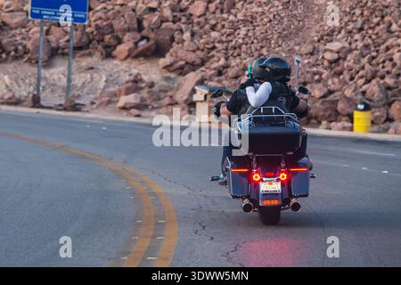 Radfahrer, Mann und Frau, fahren mit dem Motorrad auf der Bergstraße und machen Fotos von Sehenswürdigkeiten unterwegs. Zwei Motorradfahrer fahren auf dem kurvenreichen Highway mit maßgeschneidertem Hubschrauber. Hoover Dam, Nevada, USA - 2. April 2017 Stockfoto