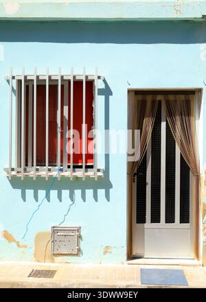 Blau lackierte Fassade mit Aluminium- und Glastür mit Kunststoffvorhang Stockfoto