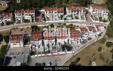 Blick aus der Vogelperspektive auf moderne Ferienvillen und Apartments in Vrachos, Griechenland. Drohnenaufnahme der Küstenstädteplanung und -Architektur am Ionischen Meer. Stockfoto