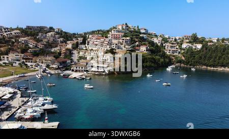 Blick aus der Vogelperspektive auf die luxuriösen Apartments und Ferienvillen auf einem grünen Hügel mit Blick auf die Bucht und den Yachthafen in Sivota, Griechenland. Mediterrane Architektur. Stockfoto