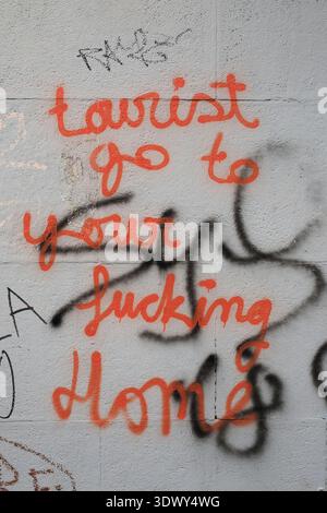 Graffiti mit den Worten: Touristen gehen zu Ihrem verdammten Haus an einer Mauer in Valencias Altstadt Stockfoto