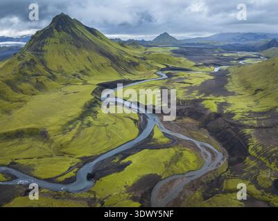 Blick aus der Vogelperspektive auf die zerklüftete vulkanische Landschaft mit Gletscherflüssen und grünen Bergen, Highlands, Island Stockfoto