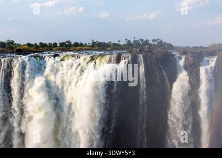 Eine Gruppe unbekannter Menschen am Rande der Victoria Falls in Simbabwe Stockfoto
