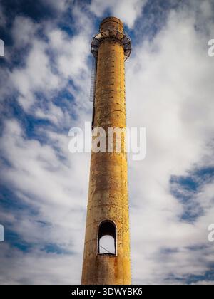 Verwitterter industrieller Schornsteinturm unter teilweise bewölktem Himmel, Erie, Pennsylvania, USA Stockfoto