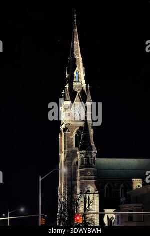 Der Uhrenturm der St. Peter Cathedral, beleuchtet bei Nacht vor dunklem Himmel, Erie, Pennsylvania, USA Stockfoto