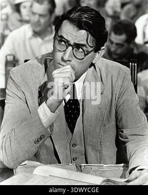 Schwarz-weiß-Werbefoto von Gregory Peck als Atticus Finch aus dem Film To Kill a Mockingbird (1962). Das Bild fängt den Schauspieler in Charakter ein, trägt einen Seersucker-Anzug und eine Brille und stellt den nachdenklichen und seriösen Anwalt dar. Stockfoto