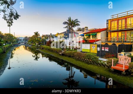 Los Angeles, CA, USA - 01. Dezember 2025: Wohngebäude säumen die Kanäle von Venedig, während warmes Sonnenuntergangslicht auf ruhigem Wasser in Venice Beach Cal reflektiert wird Stockfoto