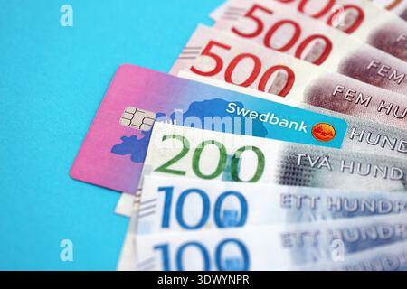 KIEW, UKRAINE - 28. JANUAR 2026 Schwedbank-Karte und schwedische Kronen-Geldscheine auf dem Tisch in Nahaufnahme. Swedbank ist die beliebteste Bank in Schweden Stockfoto